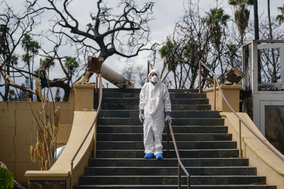 Rev. Ai Hironaka, resident minister of the Lahaina Hongwanji Mission, stands for a portrait at the stairs of his temple destroyed by wildfire, Thursday, Dec. 7, 2023, in Lahaina, Hawaii. Recovery efforts continue after the August wildfire that swept through the Lahaina community on Hawaiian island of Maui, the deadliest U.S. wildfire in more than a century. (AP Photo/Lindsey Wasson)