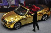 A man films a gold-plated Infiniti G37 at a jewelry store in Nanjing, Jiangsu province, March 31, 2011.