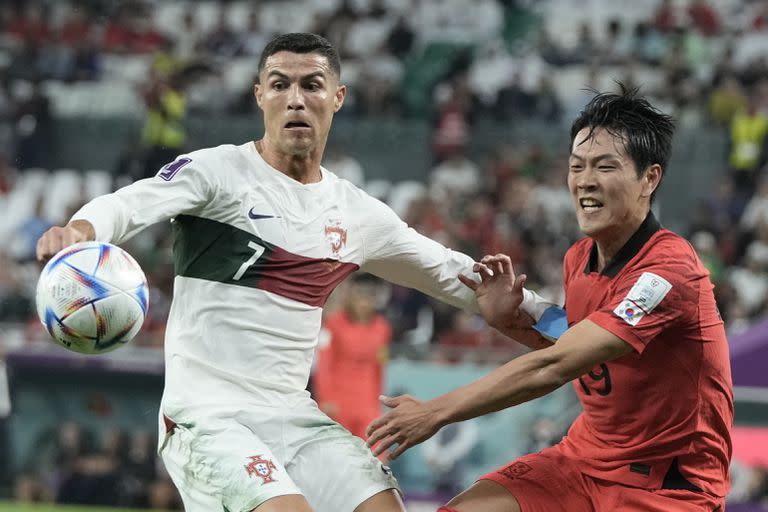El portugués Cristiano Ronaldo (izquierda) y el surcoreano Kim Young-gwon pugnan por el balón en el partido por el Grupo H del Mundial, el viernes 2 de diciembre de 2022, en Rayán, Qatar. (AP Fto/Hassan Ammar)