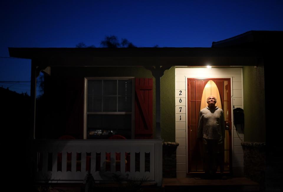 Surfer Bob Levy poses outside his house in Long Beach.