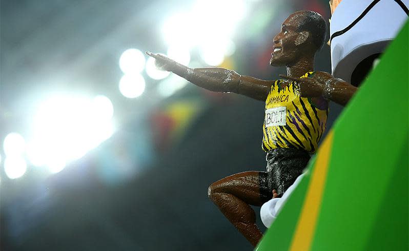 A fan holds a Usain Bolt figurine in the crowd at Olympic Stadium in Rio. Photo: Getty