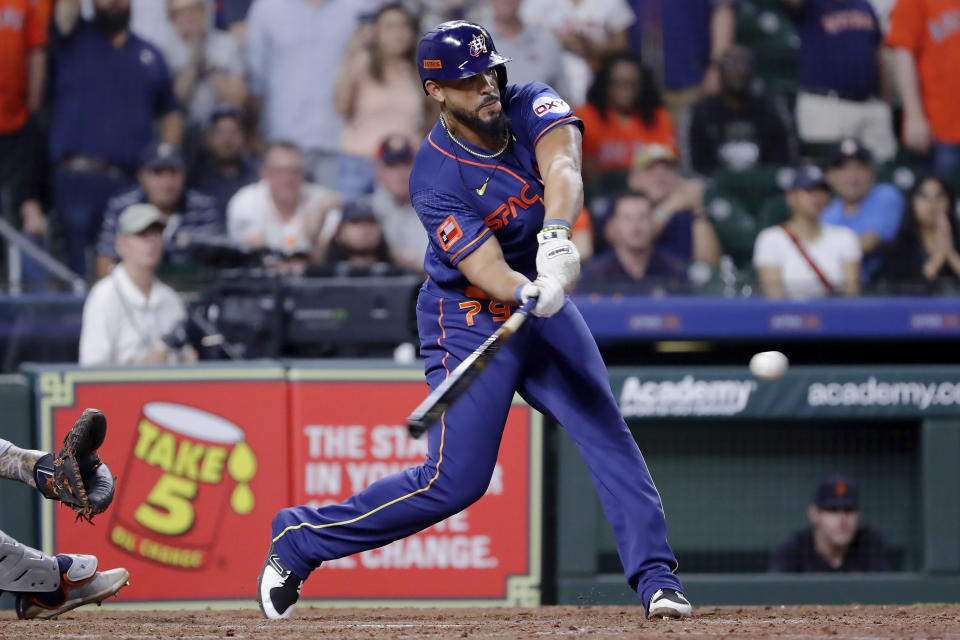 Houston Astros' Jose Abreu reaches to connect for a one-run RBI-double to tie a baseball game against the Detroit Tigers during the ninth inning Monday, April 3, 2023, in Houston. (AP Photo/Michael Wyke)