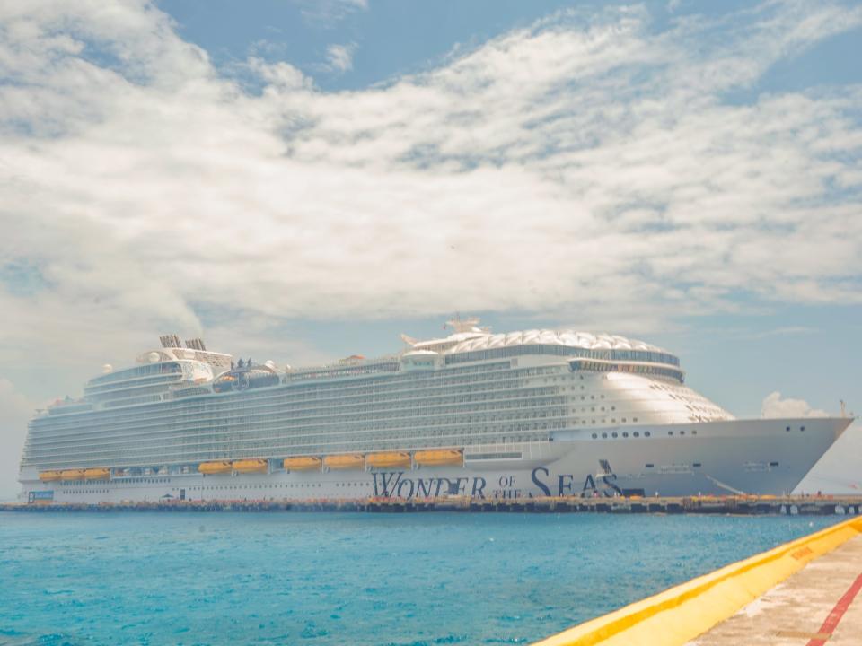 Wonder of the Seas cruise ship docked in Costa Maya over clear, blue waters on a cloudy day