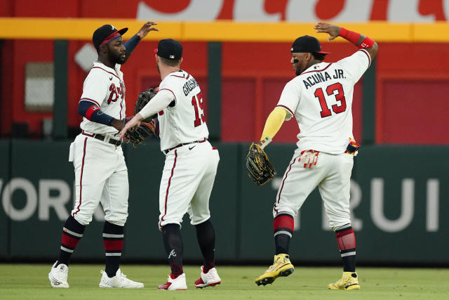 Atlanta Braves outfielders from left; Michael Harris II (23), Robbie Grossman (15), and Ronald Acuna Jr. (13) celebrate after defeating the New York Mets 5-0 in a baseball game Tuesday, Aug. 16, 2022, in Atlanta. (AP Photo/John Bazemore)
