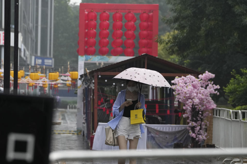 A woman uses an umbrella during a rainy day in Beijing, Sunday, Aug. 14, 2022. (AP Photo/Ng Han Guan)