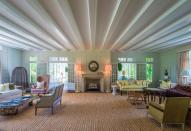 <p>This massive living room boasts beamed ceilings and a stone fireplace. <br> (Christie’s International Real Estate) </p>