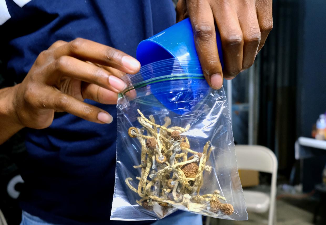 A vendor bags psilocybin mushrooms in a pop-up cannabis market in Los Angeles.