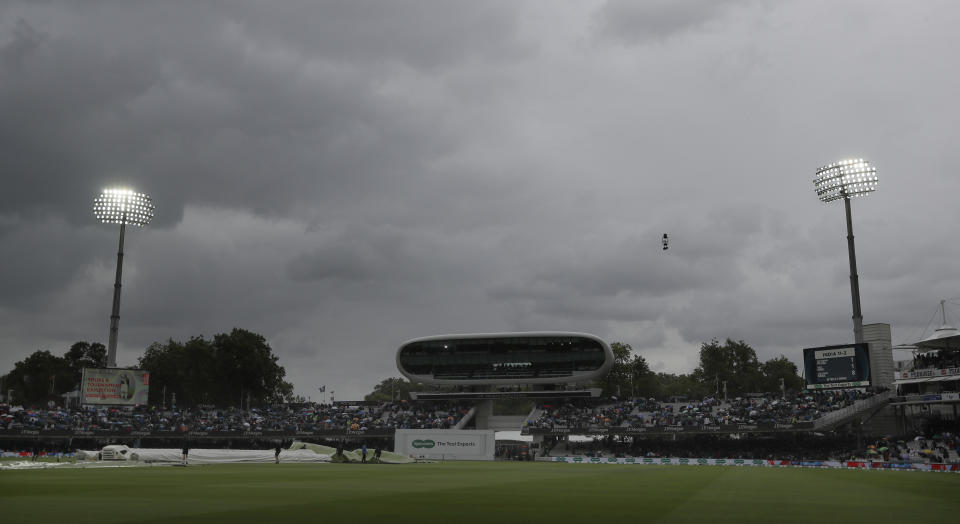 Rain covers are pulled onto the pitch as rain stops play during the second day of the second test match between England and India at Lord's cricket ground in London, Friday, Aug. 10, 2018. (AP Photo/Kirsty Wigglesworth)