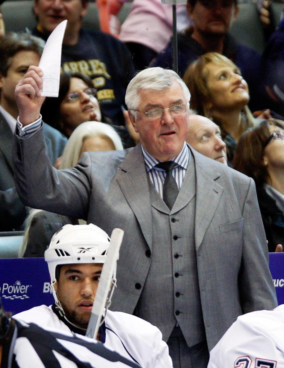 Oilers head coach Quinn waves from behind the Oilers bench during their NHL hockey game against the Maple Leafs in Toronto in this file photo