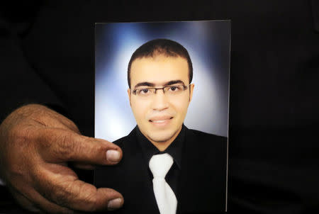 Reda Abdullah al-Hamamy, the father of Abdullah Reda al-Hamamy who is suspected of attacking a soldier in Paris' Louvre museum, holds a picture of his son during an interview with Reuters in Daqahliya, Egypt, February 4, 2017. REUTERS/Mohamed Abd El Ghany