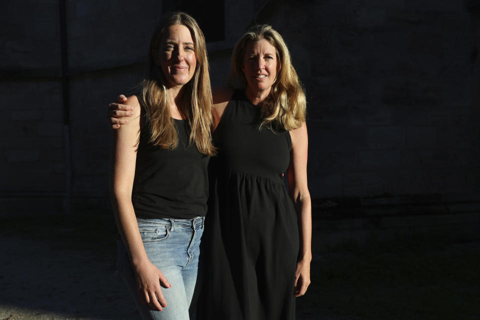 Hillary Jackson, from New York, right, and Kristy Benner, from Los Angeles, pose outside the Saint-Andre hospital in Bordeaux, southwestern France, Thursday, Sept.14, 2023. Kristy Benner's partner Matt Jackson was riding an electric bike through Bordeaux wine country on vacation when he started feeling strange. Nine days later, he's on a breathing machine in a French ICU, unable to open his eyes, communicating only via notes on a whiteboard and infected with botulism. A 32-year-old woman died in France and eight other people remained hospitalized Thursday after an apparent botulism outbreak linked to homemade sardine preserves and the wine bar in Bordeaux. (AP Photo/Sophie Garcia)