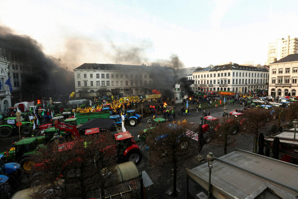 Smoke rises from a fire burning as farmers from Belgium and other European countries use their tractors to block the European Parliament, as they protest over price pressures, taxes and green regulation, on the day of an EU summit in Brussels, Belgium February 1, 2024. REUTERS/Yves Herman