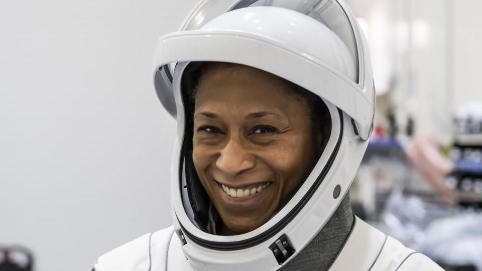 a smiling woman in a space suit