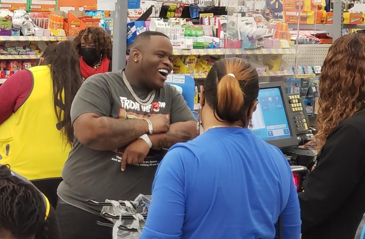 Hip-hop artist Morray laughs with a cashier at Walmart on Hope Mills on Tuesday afternoon, Dec. 21, 2021. The rapper was buying gifts to give out at a charity event scheduled for Thursday in downtown Fayetteville.