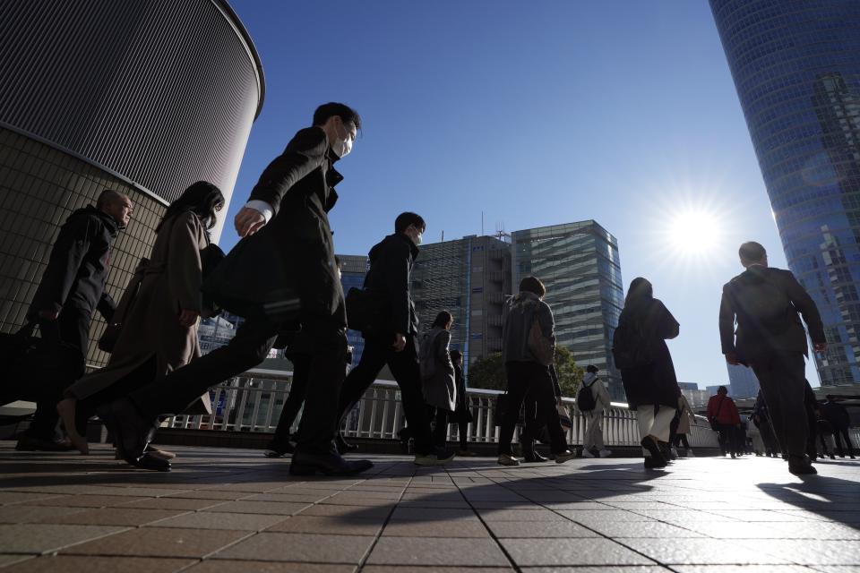 FILE - Commuters walk in a passageway during a rush hour at Shinagawa Station, Feb. 14, 2024, in Tokyo. (AP Photo/Eugene Hoshiko, File)