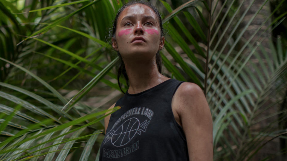 Erana James stands in the jungle wearing pink war paint in The Wilds.