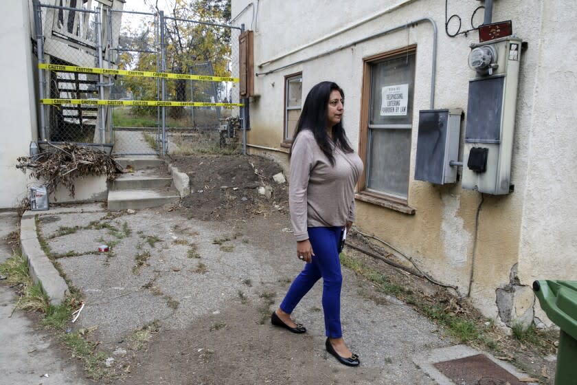 Los Angeles, CA - December 03: Lisas Mauricio, a community leader and member of Citizen Advisory Committe, at a vacant home on Shelley Street, one of many properties owned by CalTrans. Proposed El Sereno Vision Plan calls for purchasing and redeveloping 77 vacant parcels along the 710 freeway corridor in the community of El Sereno on Friday, Dec. 3, 2021 in Los Angeles, CA. (Irfan Khan / Los Angeles Times)