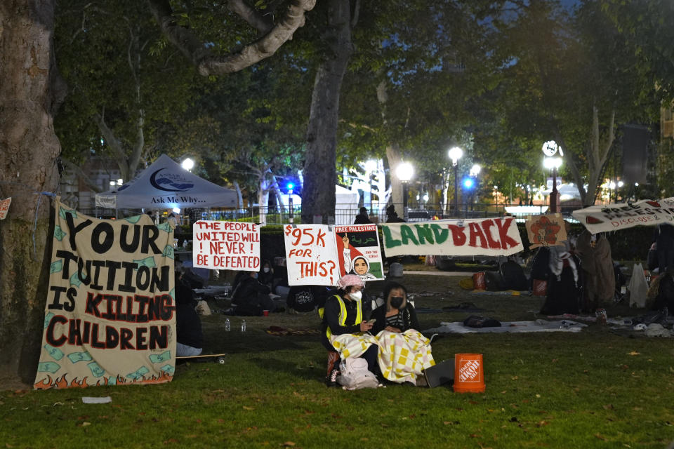 People stand guard outside an encampment set up by pro-Palestinian demonstrators on the campus at the University of Southern California Saturday, May 4, 2024, in Los Angeles. (AP Photo/Ryan Sun)
