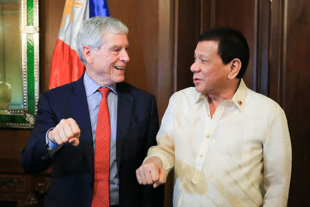 President Rodrigo Duterte poses with his signature fist bump with Australian Secret Intelligence Service Director General Nicolas Peter 'Nick' Warner who paid a courtesy call on the President at the Malacanan Palace, in Manila Philippines, August 22, 2017. Presidential Palace/Handout via REUTERS