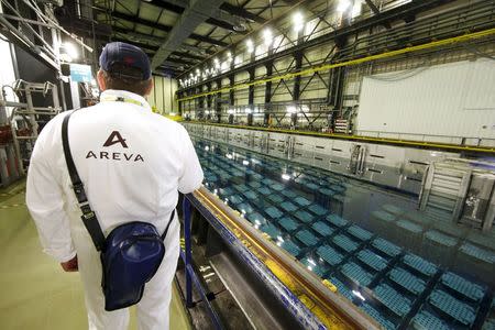 A technician walks along the pool storage where spent nuclear fuel tanks are unloaded in baskets under 4 meters of water to decrease temperature as part of the treatment of nuclear waste at the Areva Nuclear Plant of La Hague, near Cherbourg, western France, in this April 22, 2015 file photo. REUTERS/Benoit Tessier/Files