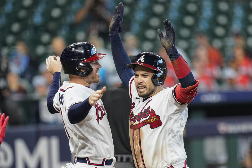 Atlanta Braves' Travis d'Arnaud, right, celebrates with teammate Freddie Freeman after hitting a three-run home run during the seventh inning in Game 1 of a baseball National League Division Series against the Miami Marlins Tuesday, Oct. 6, 2020, in Houston. (AP Photo/Eric Gay)