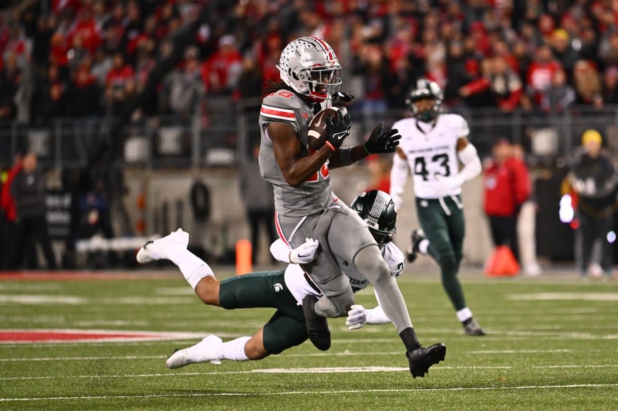 COLUMBUS, OHIO – NOVEMBER 11: Marvin Harrison Jr. #18 of the Ohio State Buckeyes breaks away from a tackle by Ade Willie #20 of the Michigan State Spartans during the third quarter of a game at Ohio Stadium on November 11, 2023 in Columbus, Ohio. (Photo by Ben Jackson/Getty Images)