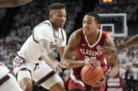 Alabama guard Nimari Burnett (25) is covered up by Texas A&M guard Dexter Dennis (0) and other Aggie defenders while trying to drive the lane during the first half of an NCAA college basketball game Saturday, March 4, 2023, in College Station, Texas. (AP Photo/Sam Craft)