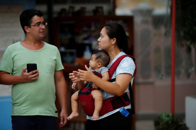 Vararunee Khonchanath, 35, chats with a man in Santa Cruz Church, ahead of Pope Francis' visit to Thailand, in Bangkok