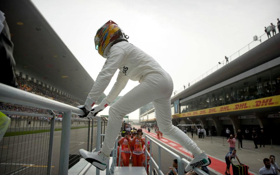 Lewis Hamilton goes to salute his fans - Credit: AP