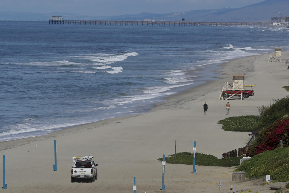 FILE - In this March 25, 2020, file photo, lifeguards patrol a closed section of the beach in Carlsbad, Calif. A memo sent to California police chiefs says Gov. Gavin Newsom will order all beaches and state parks closed starting Friday, May 1, to curb the spread of the coronavirus. The California Police Chiefs Association sent the bulletin to its members Wednesday evening. Association President Eric Nuñez said it was sent to give chiefs time to plan ahead of Newsom’s expected announcement Thursday. (AP Photo/Chris Carlson, File)