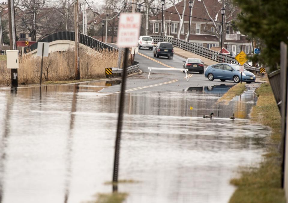 Cars are turned around or otherwise diverted on Patten Avenue in Monmouth Beach, N.J., because of road flooding.