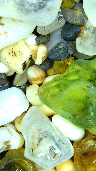 Artificial sea glass doesn’t have the same pitted texture as real sea glass. Pictured here in green is real sea glass, with small, textured marks across its surface. Lori Weeden