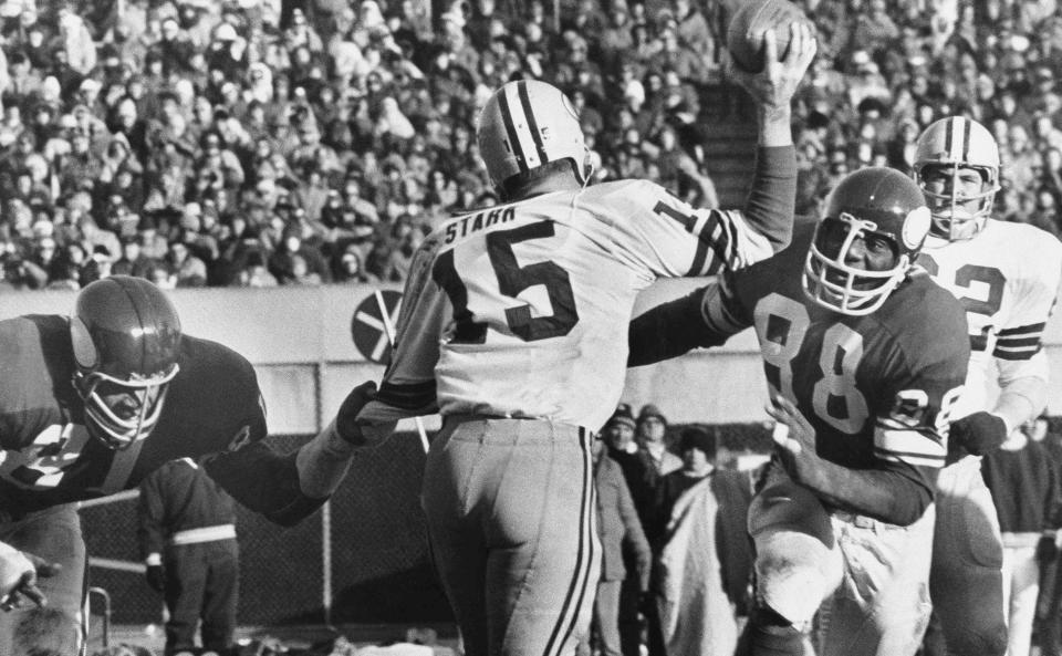 File-This Nov. 23, 1970 file photo shows Green Bay Packers quarterback Bart Starr (15) looking for a receiver as Minnesota Vikings Alan Page (88) charges him and Carl Eller (81), left, grabs his arm during the second half of an NFL game in Minneapolis, Minn. Pro Football Hall of Fame defensive tackle and retired Minnesota state supreme court justice Page has counted art collection among his many life pursuits, and the former Vikings star has two of his prized pieces up for sale through a New York auction house, each valued at more than $200,000. (AP Photo/File)