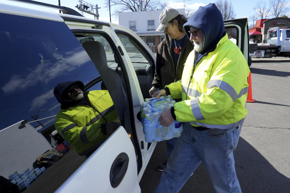 Volunteer Larry Culler helps load water into a car in East Palestine, Ohio, as cleanup from the Feb. 3 Norfolk Southern train derailment continues, Friday, Feb. 24, 2023. (AP Photo/Matt Freed)