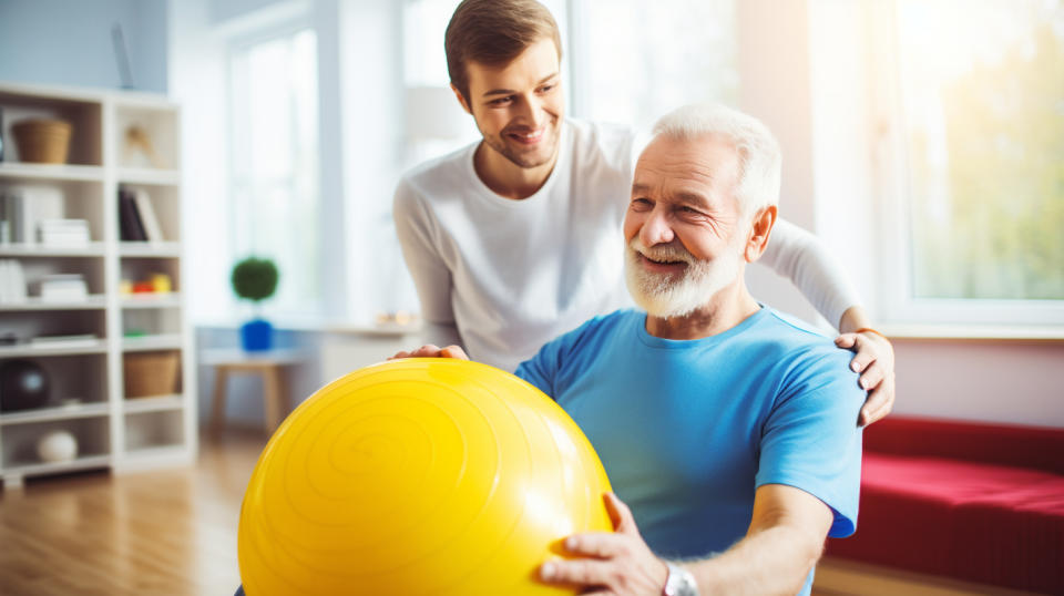 A healthcare professional providing physical therapy to an elderly patient.