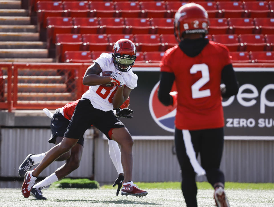Calgary Stampeders' Kamar Jorden, left, catches a pass as Jonathan Moxey looks on during opening day of the Canadian Football League team's training camp in Calgary, Alberta, Sunday, May 15, 2022. (Jeff McIntosh/The Canadian Press via AP)