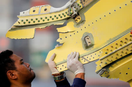 FILE PHOTO: An Indonesian National Transportation Safety Commission (KNKT) official carries debris from the crashed Lion Air flight JT610 at Tanjung Priok port in Jakarta, Indonesia, November 4, 2018. REUTERS/Beawiharta/File Photo