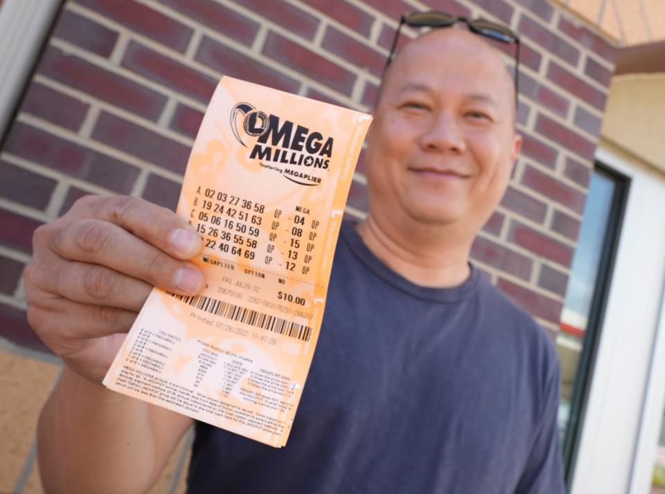 Doa Yang of Sheboygan shows off his freshly purchased Mega Millions lottery tickets outside of Kwik Trip on West Ryan Road in Oak Creek on Thursday, July 28, 2022. The Mega Millions lottery jackpot ballooned to $1.02 billion after no one matched all six numbers Tuesday night and won the top prize.