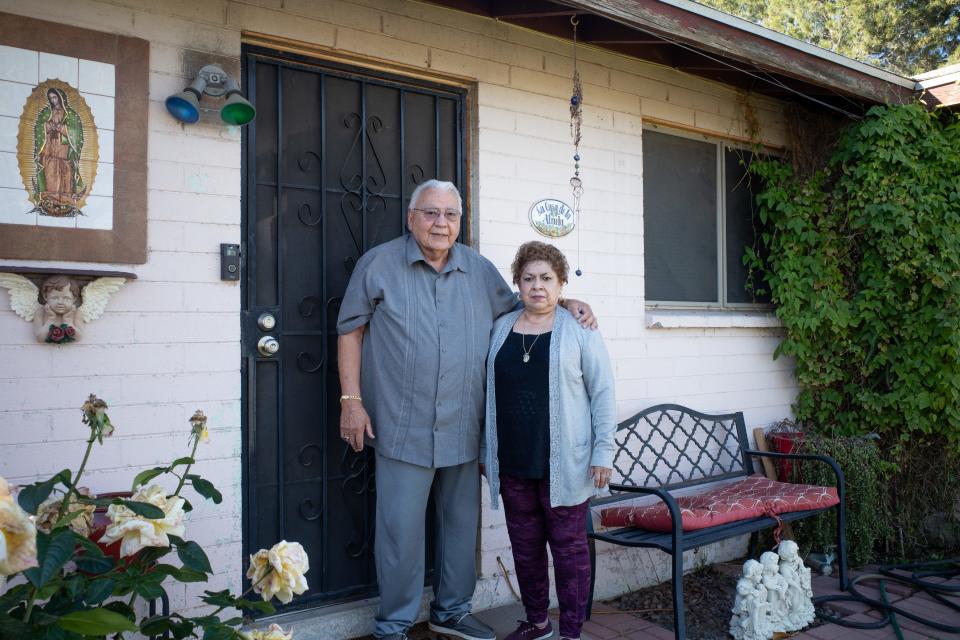 Armando "Dan" Reyes, 77, and Ramona Barraza, 78, pose in front of their home in Maryvale.