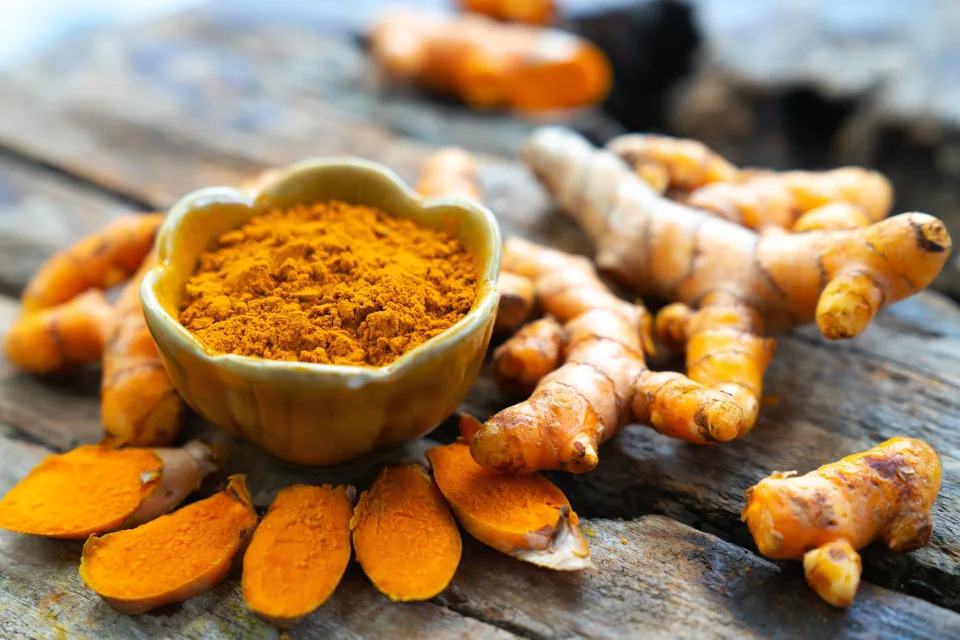 Turmeric root and powder in a bowl