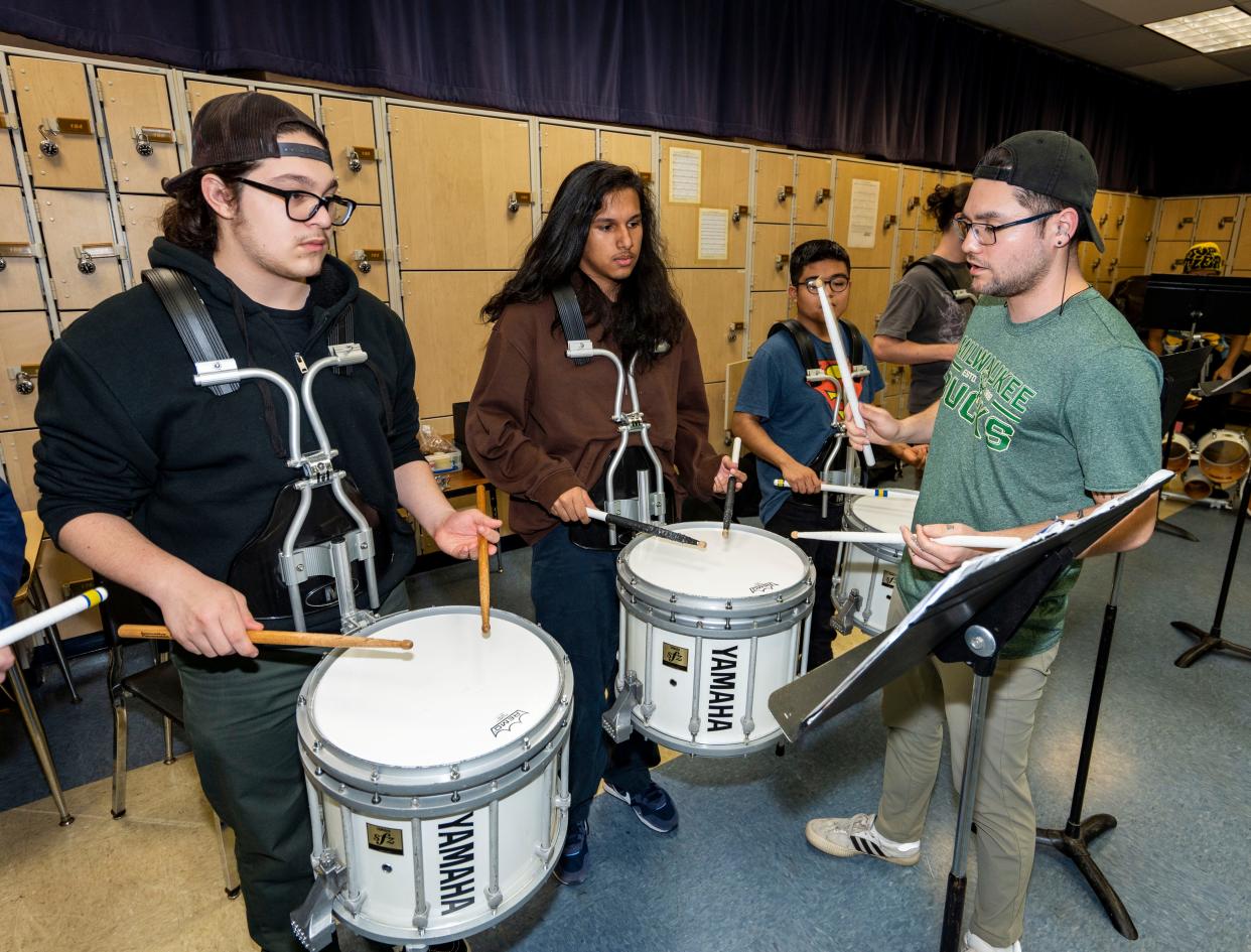 Drumline instructor Mr. Collin, right, runs through drills with Reagan High School sophomore Diego Avila and sophomore Mateo De Haan as they prepare for the MPS 50th Biennial Music Festival.