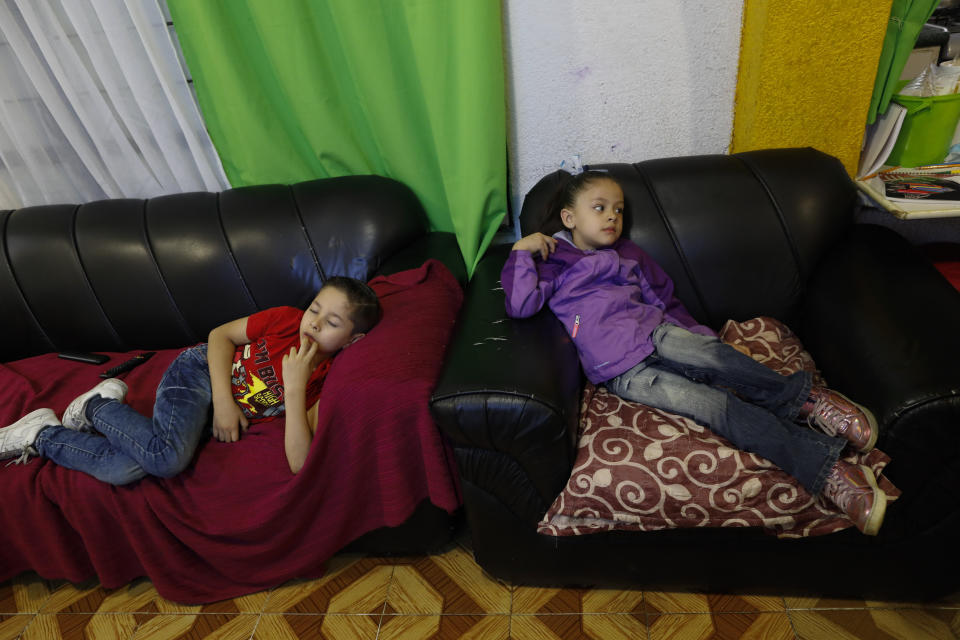 Santi, 6, and his sister Liz, 5, struggle to focus on a televised kindergarten lesson as students return to classes but not schools in Mexico City, Monday, Aug. 24, 2020. A system cobbling together online classes, instruction broadcast on cable television channels and radio programming in indigenous languages for the most remote, will attempt to keep students from missing out. (AP Photo/Rebecca Blackwell)