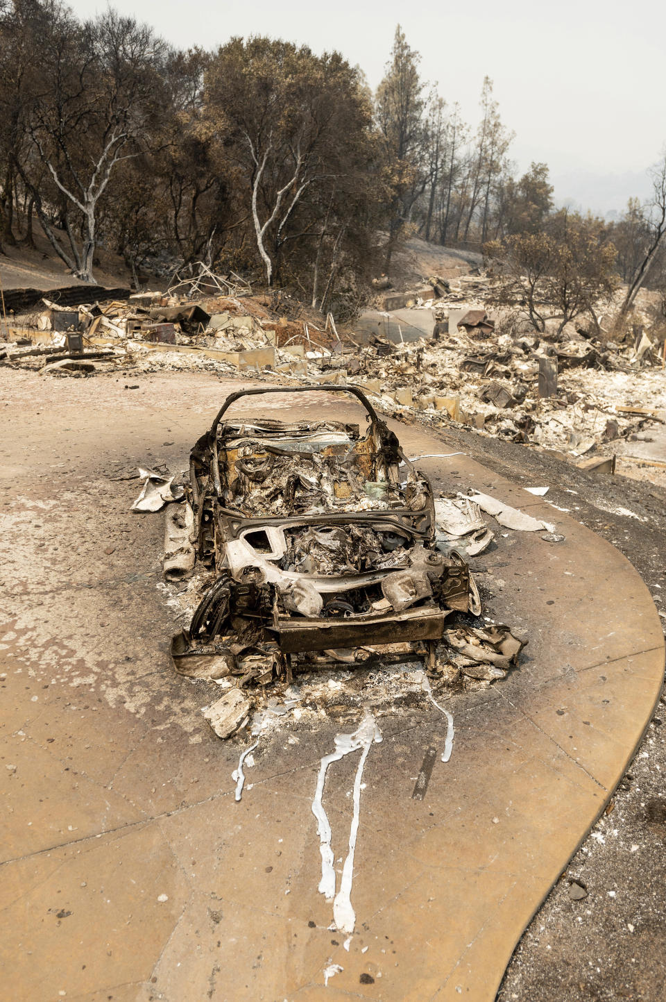 A scorched vehicle rests in a driveway following the LNU Lightning Complex fires in Napa County, Calif. on Monday, Aug. 24, 2020. (AP Photo/Noah Berger)