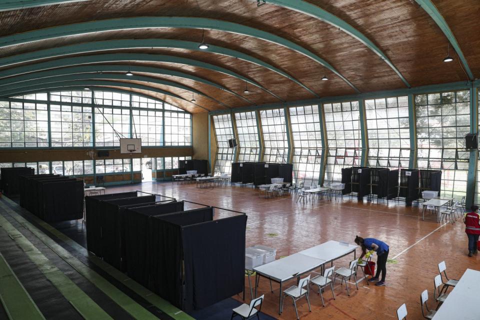 A worker wipes a chair at a gymnasium that will serve as a polling station in Santiago, Chile.