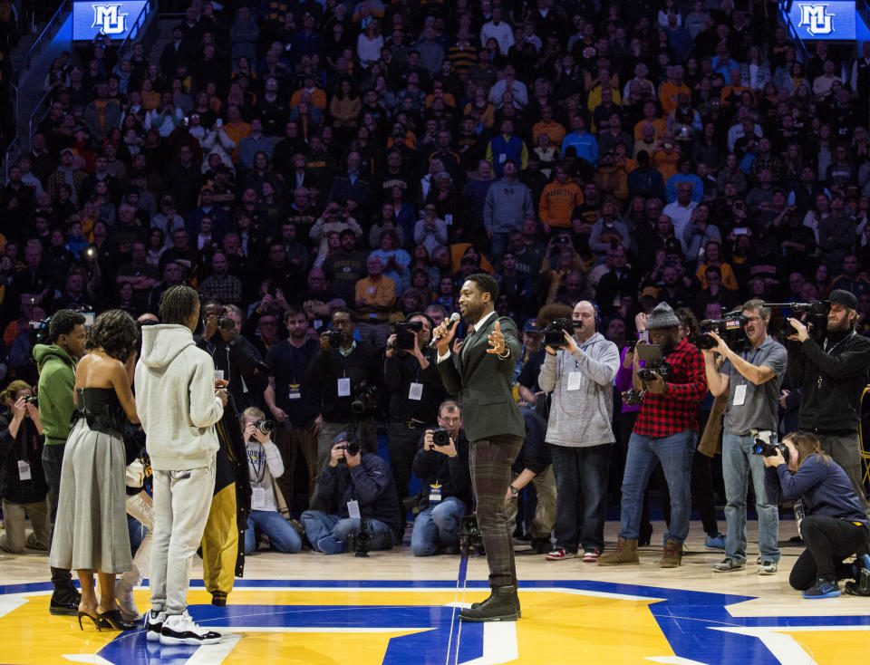 Miami Heat player and Marquette alumni Dwyane Wade, center, is honored with Dwyane Wade Day during half time as Marquette takes on Providence for an NCAA college basketball game Sunday, Jan. 20, 2019, in Milwaukee. (AP Photo/Darren Hauck)