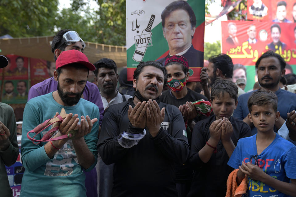 Supporters of Pakistan's former Prime Minister Imran Khan pray after hearing the court decision, in Lahore, Pakistan, Friday, May 12, 2023. A high court in Islamabad has granted former Prime Minister Imran Khan a two-week reprieve from arrest in a graft case and granted him bail on the charge. (AP Photo/K.M. Chaudary)