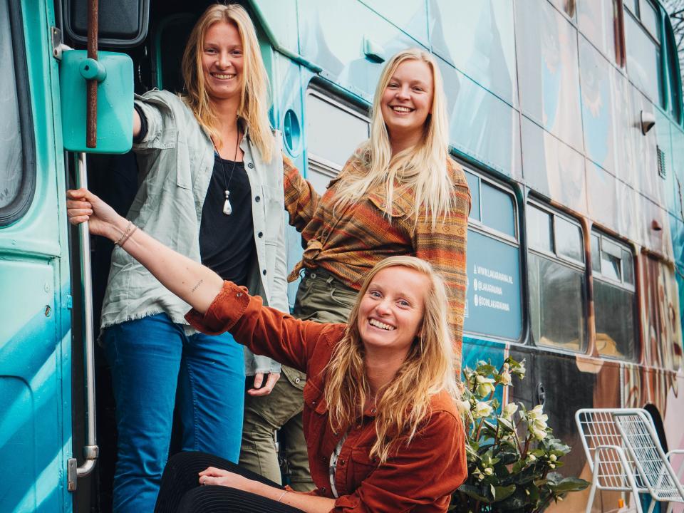 the author and her twin sister, and best friend hanging outside the double-decker bus