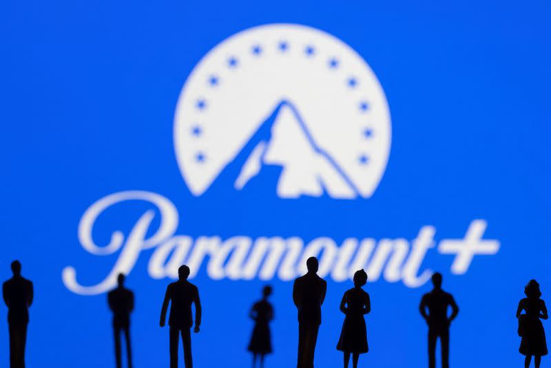 FILE PHOTO: Toy figures of people are seen in front of the displayed Paramount + logo, in this illustration