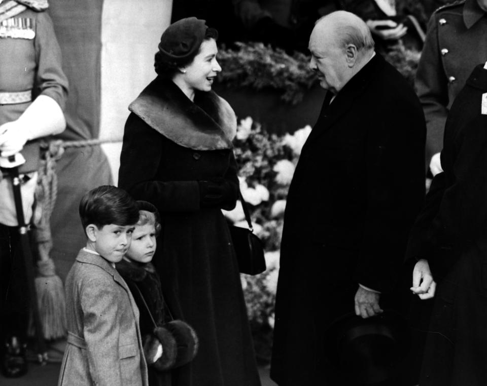 1953:  Elizabeth II, Queen of England with Prince Charles and Princess Anne chatting to Sir Winston Churchill (1874 - 1965).  (Photo by Central Press/Getty Images)