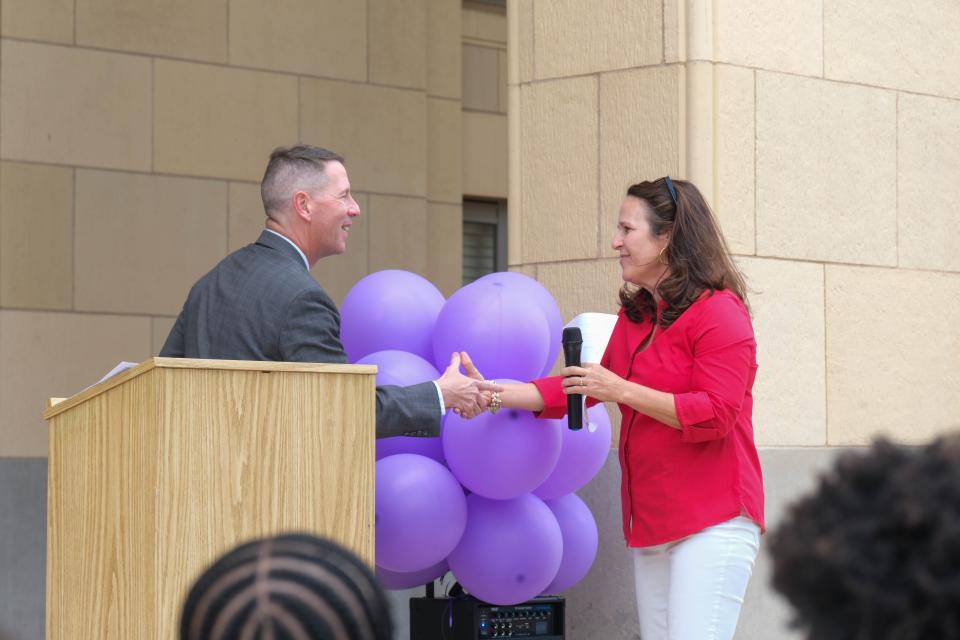 Randall County District Attorney Robert Love greets Jane Jackson, wife of Rep. Ronny Jackson, Monday afternoon at the Community Walk Against Domestic Violence in downtown Amarillo.